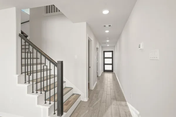a view of a hallway with wooden floor and staircase