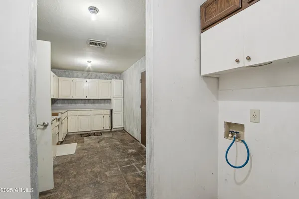 a view of an empty room and chandelier fan
