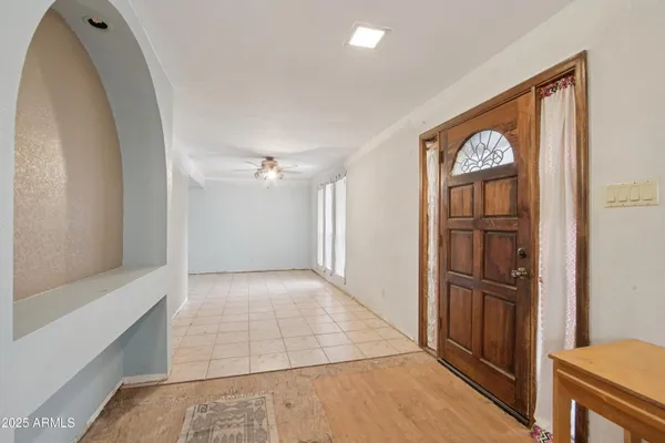 a view of a livingroom with a dinning area hardwood floor and a ceiling fan