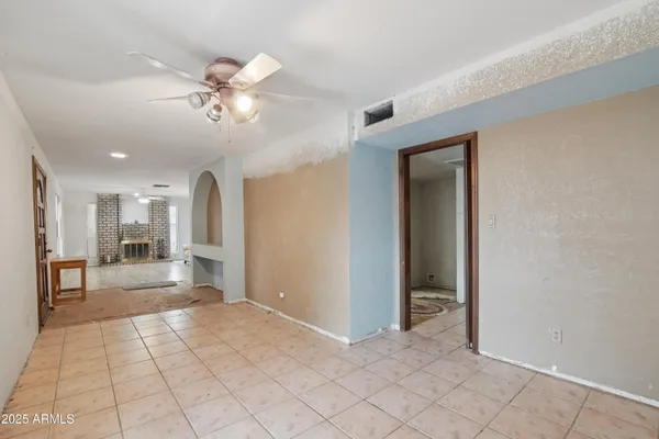 a view of a livingroom with a chandelier fan and windows
