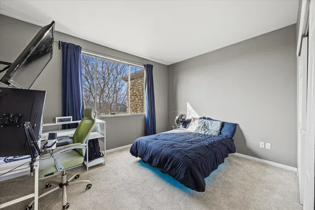a bedroom with a bed chair and a window