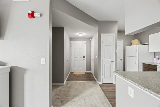 a view of kitchen with granite countertop cabinets and refrigerator