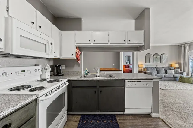 a kitchen with cabinets a sink and white appliances