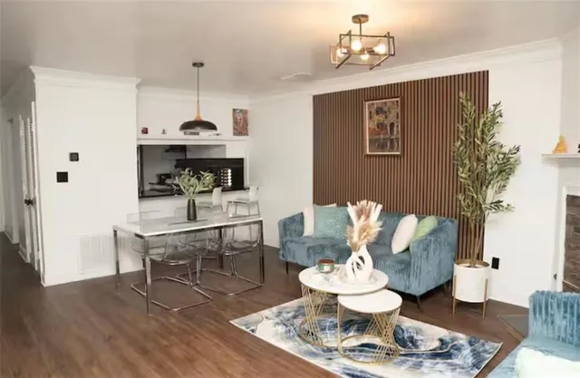 a living room with furniture and a dining table with wooden floor