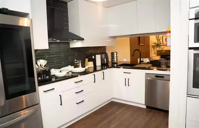 a kitchen with white cabinets and appliances