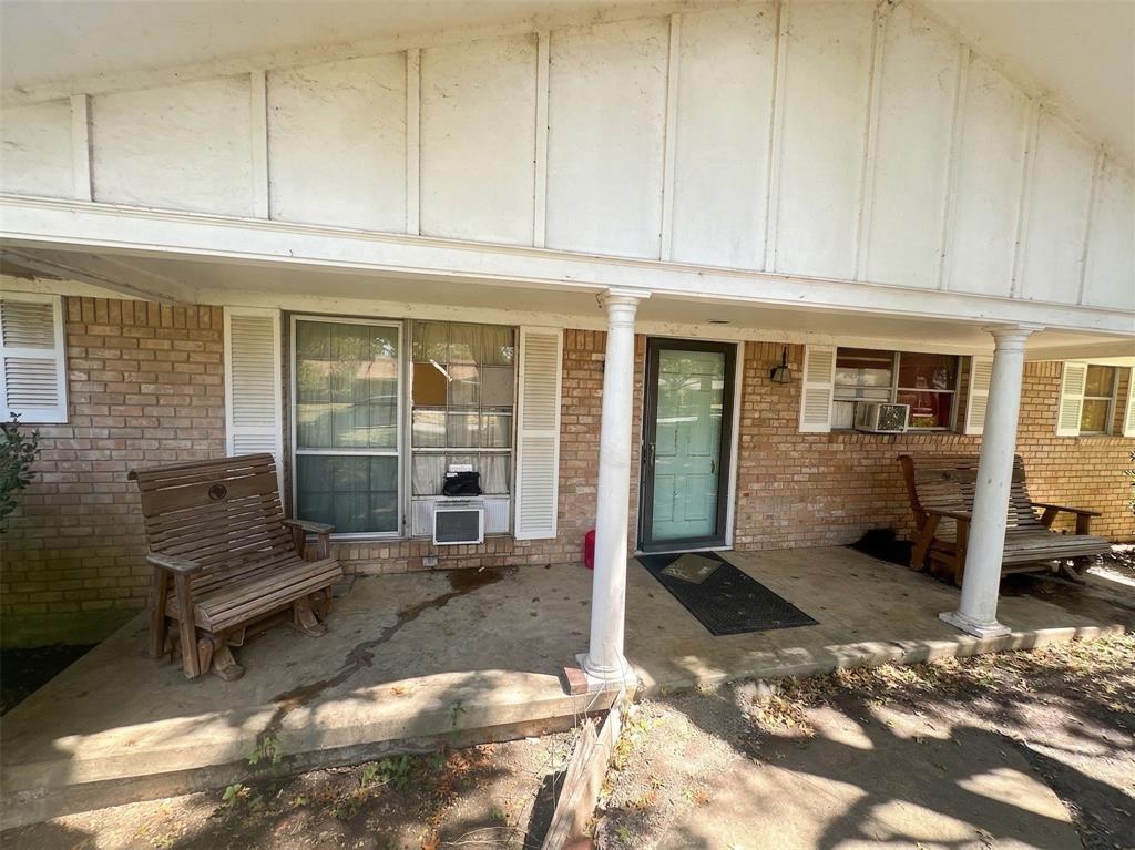 409 Whitehall Road Woodway, TX 76712 - Photo 2 of 3 Doorway to property featuring brick siding and board and batten siding