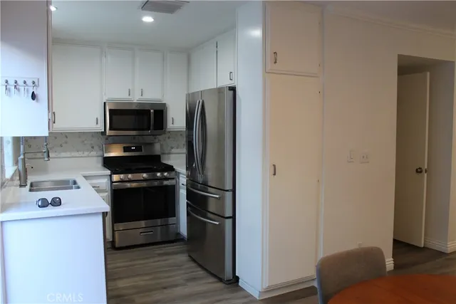 a kitchen with stainless steel appliances a refrigerator stove and microwave