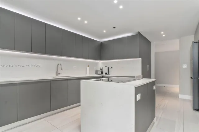 a kitchen with stainless steel appliances granite countertop a sink and a refrigerator