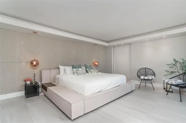a spacious bedroom with a bed and glass walk in closet