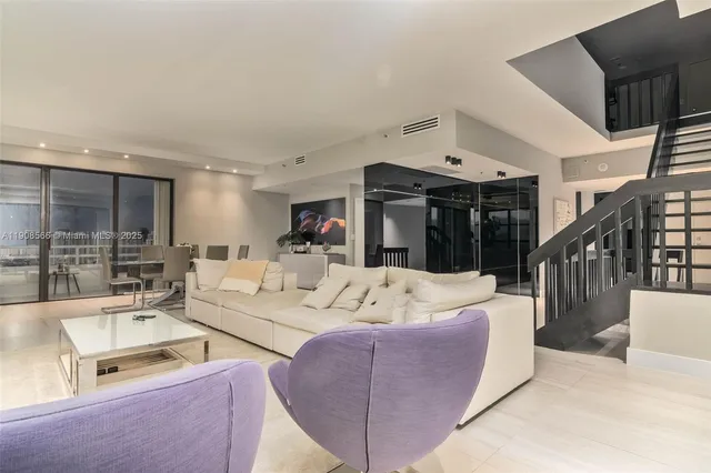 a living room with furniture large window and a table