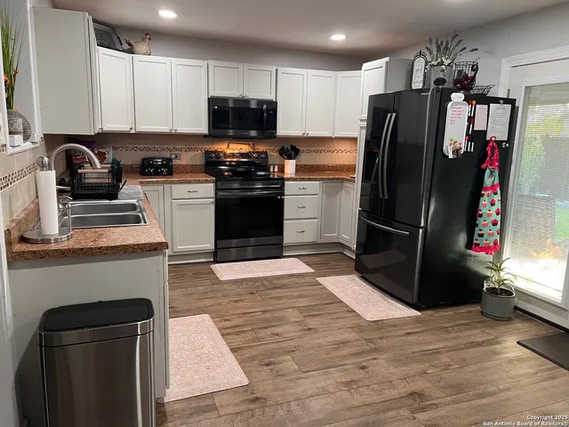 a kitchen with a refrigerator stove and wooden cabinets