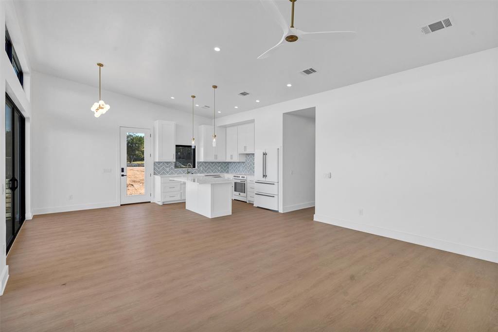 1782 Fm 2951, Unit 28 Graford, TX 76449 - Photo 12 of 30 a view of a kitchen with a sink and dishwasher a refrigerator with white cabinets