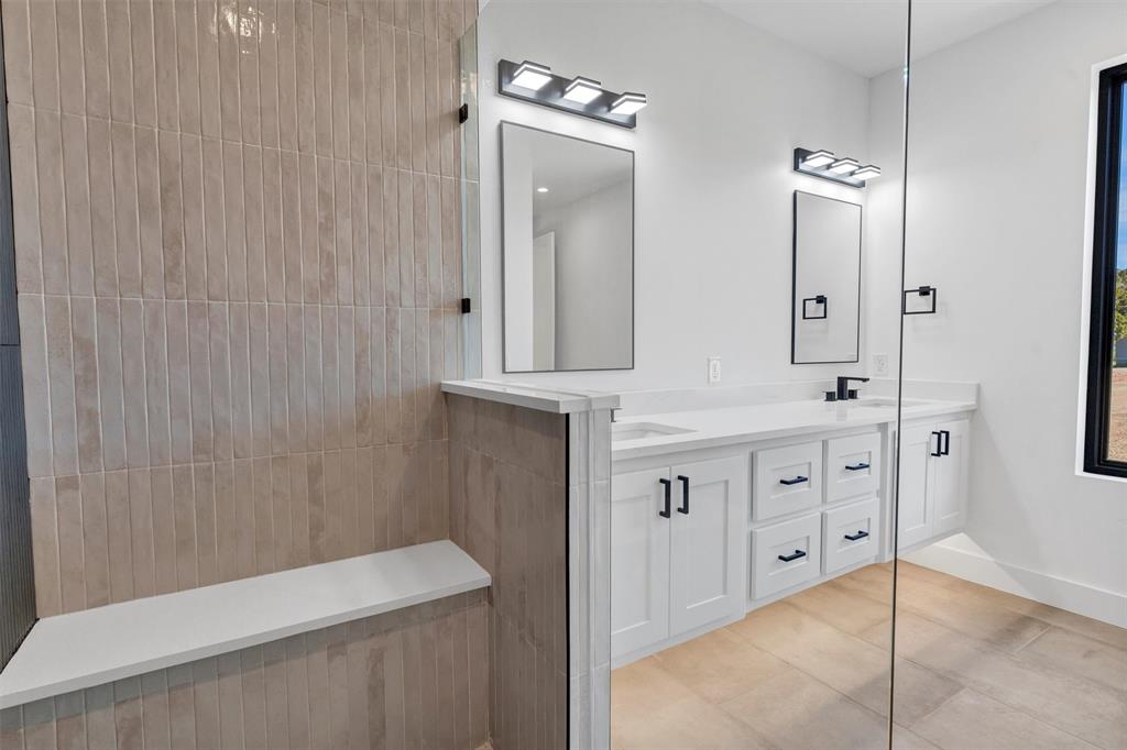 1782 Fm 2951, Unit 28 Graford, TX 76449 - Photo 27 of 30 a bathroom with a double vanity sink a toilet and a mirror