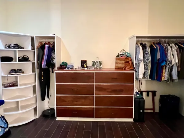 a view of walk in closet with clothes and shoes