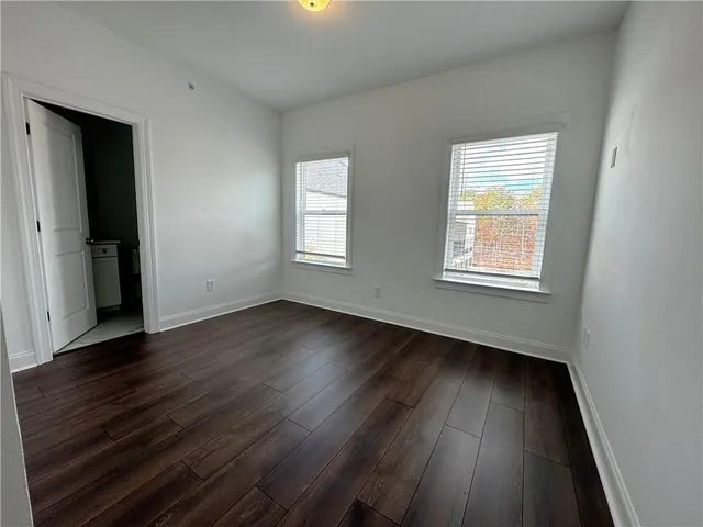 a view of a room with wooden floor and white walls