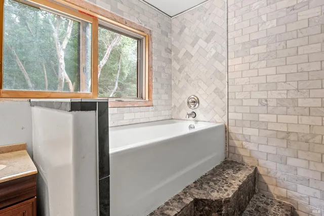 a bathroom with a tub and a window