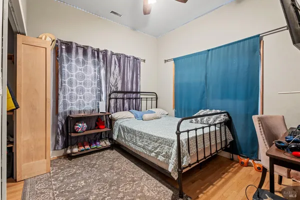 a bedroom with a bed window and a chair