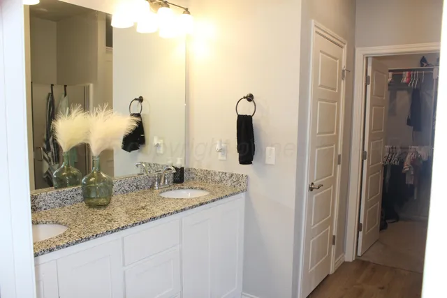 a bathroom with a granite countertop sink and a mirror