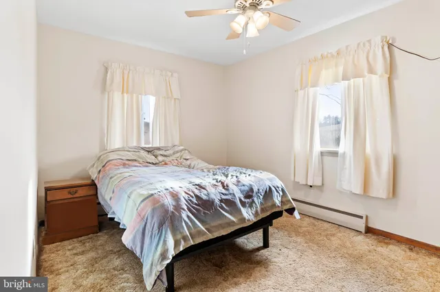 a bed sitting in a bedroom next to a window and a chandelier