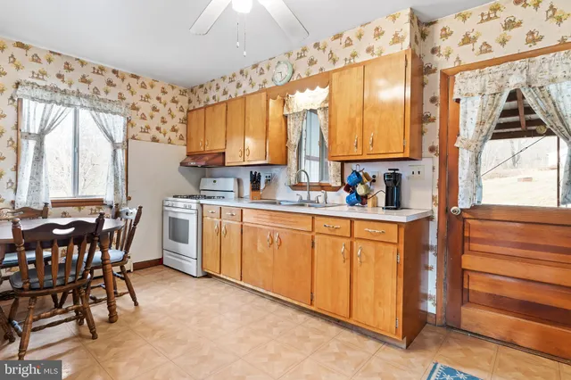 a kitchen with appliances cabinets and chair