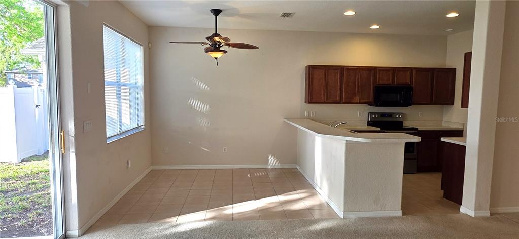 10906 Tree Cactus Loop Land O Lakes, FL 34638 - Photo 18 of 62 a kitchen with kitchen island granite countertop a refrigerator and a sink