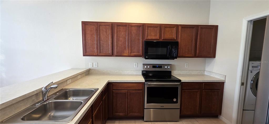10906 Tree Cactus Loop Land O Lakes, FL 34638 - Photo 23 of 62 a kitchen with a sink stove and microwave