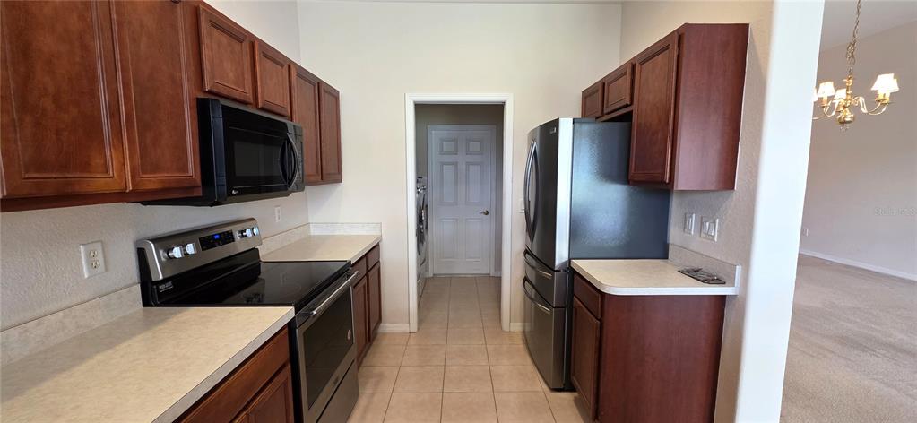 10906 Tree Cactus Loop Land O Lakes, FL 34638 - Photo 24 of 62 a kitchen with stainless steel appliances granite countertop a refrigerator a stove top oven a sink and dishwasher