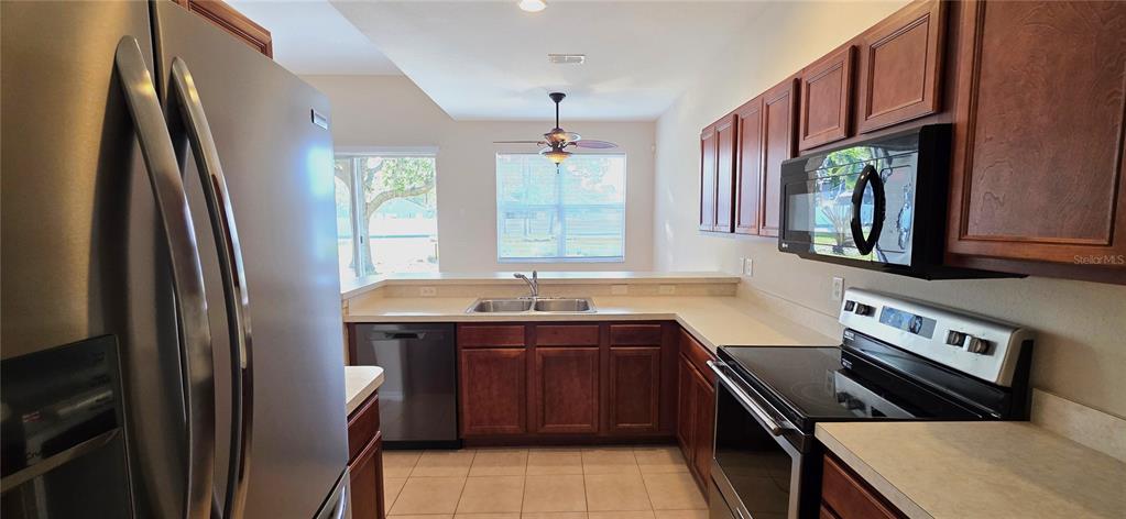 10906 Tree Cactus Loop Land O Lakes, FL 34638 - Photo 26 of 62 a kitchen with stainless steel appliances granite countertop a sink stove and refrigerator