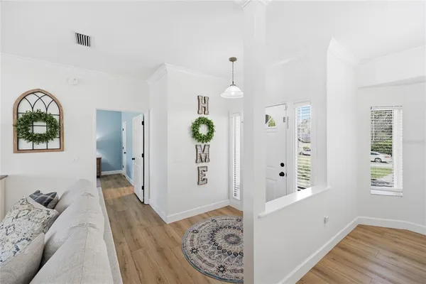 a view of a dining room with furniture a chandelier and wooden floor