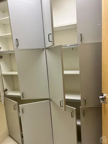 a view of walk in closet with empty racks