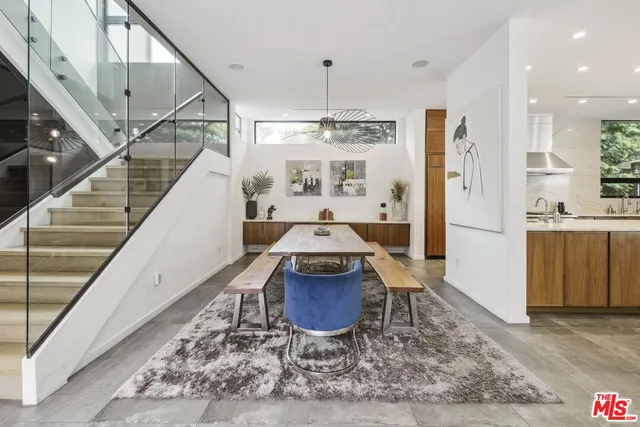 a living room with stainless steel appliances granite countertop furniture and a wooden floor