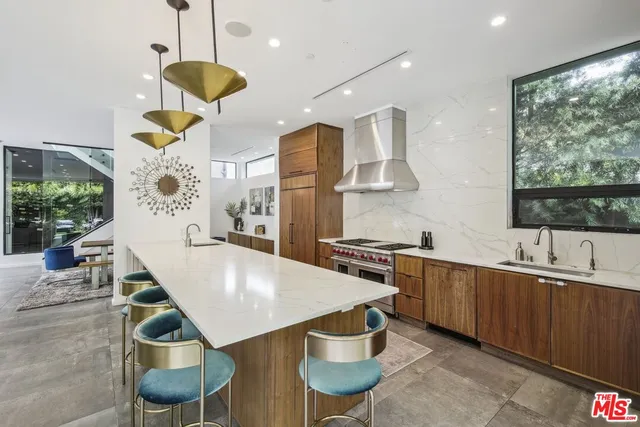 a kitchen with stainless steel appliances granite countertop a sink a stove and a refrigerator