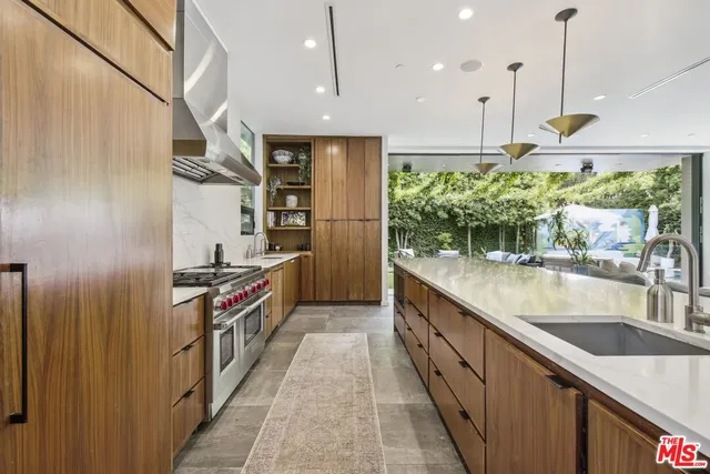 a kitchen with stainless steel appliances granite countertop a sink a stove and a refrigerator