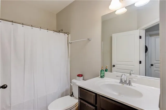 a bathroom with a sink vanity mirror and toilet