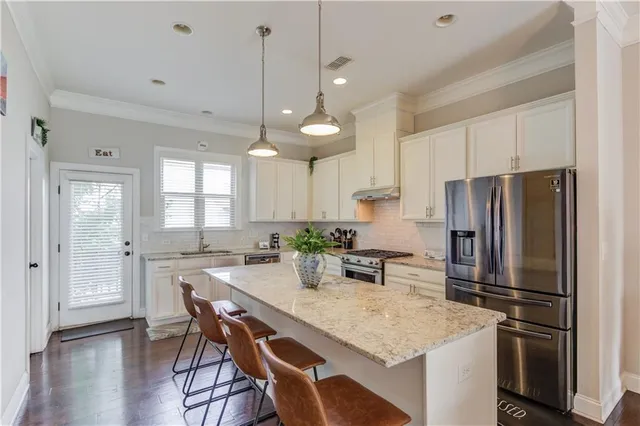 a kitchen with refrigerator a sink and chairs