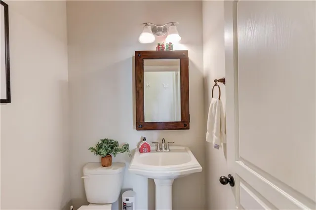a bathroom with a toilet sink and mirror