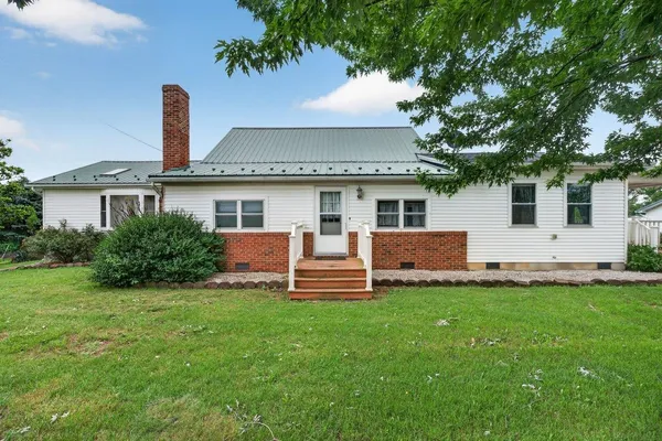 a front view of a house with a garden and plants