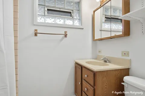 a bathroom with a sink a toilet and a window