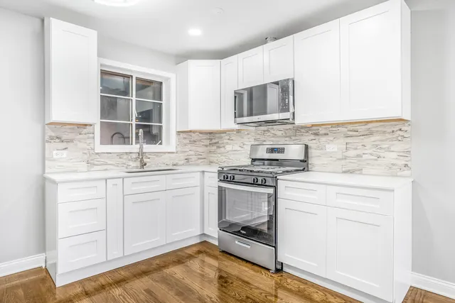 a kitchen with stainless steel appliances granite countertop a sink stove and microwave
