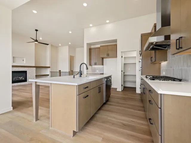 a large white kitchen with a stove top oven a sink a counter space and cabinets