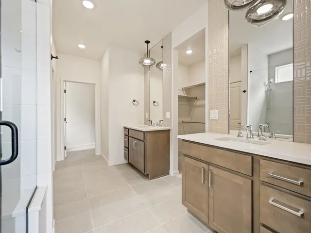 a bathroom with a double vanity sink mirror and shower