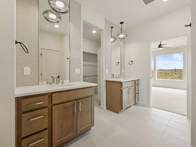 a bathroom with a granite countertop sink a mirror a vanity and a bathtub