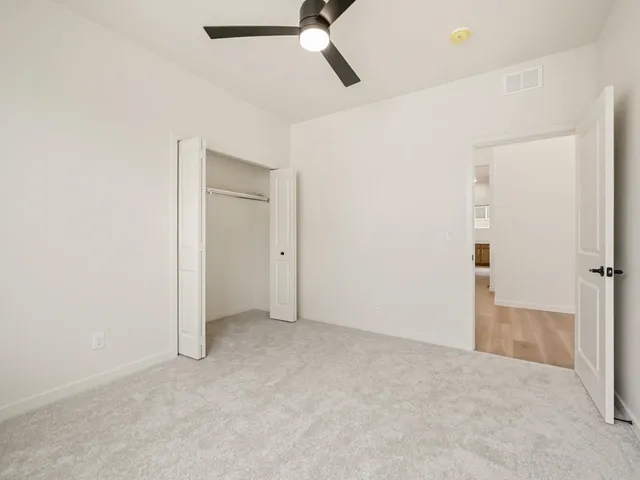 an empty room with closet and windows