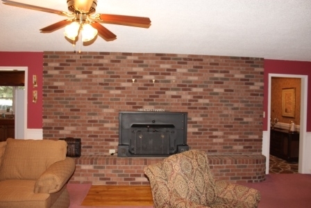 159 Floyd Road Forsyth, GA 31029 - Photo 4 of 31 a living room with a fireplace and a chandelier