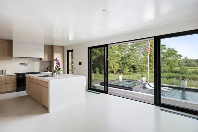 a large white kitchen with a large window