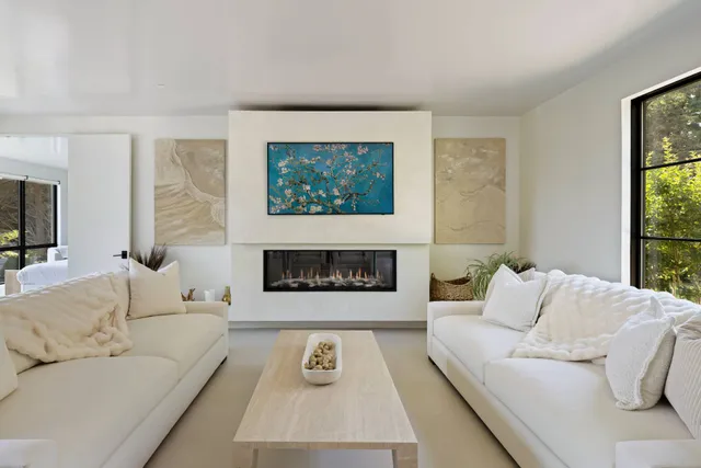 a living room with furniture a fireplace and a large window