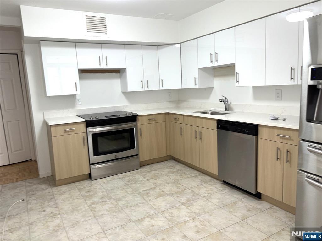 344 Prospect Avenue, Unit 9G Hackensack, NJ 07601 - Photo 11 of 16 a kitchen with a stove sink and cabinets