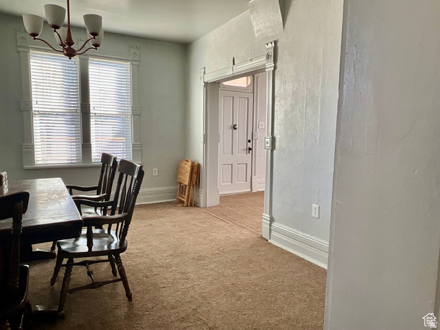 495 North Main Street Beaver, UT 84713 - Photo 6 of 18 Carpeted dining area with a chandelier and a textured wall
