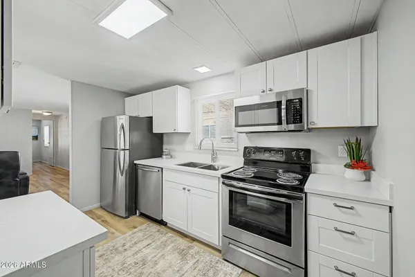 a kitchen with stainless steel appliances a stove a sink and a refrigerator