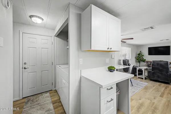 a view of a kitchen with furniture and wooden floor